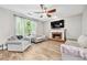 Cozy living room with a fireplace, gray couches, a ceiling fan and new wood-look floors at 3220 Goldmist Dr, Buford, GA 30519