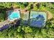 Aerial view of the sparkling pool and tennis courts, surrounded by lush trees and landscaped grounds at 3220 Goldmist Dr, Buford, GA 30519
