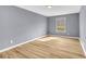 Bedroom with light laminate flooring and a large window overlooking greenery at 6684 Heathrow Ln, Stone Mountain, GA 30087