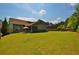 Large, lush backyard with manicured lawn, covered patio and mature trees at 1005 Woodbury Rd, Canton, GA 30114