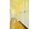 Hallway with hardwood floors and white built-in cabinets for ample storage at 1005 Woodbury Rd, Canton, GA 30114