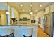 Well-lit kitchen with stainless steel appliances, breakfast bar and hardwood floors at 1005 Woodbury Rd, Canton, GA 30114