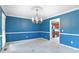 Charming dining room with wainscoting, a chandelier, and a glimpse into the kitchen at 21 Wisteria Run, Hiram, GA 30141