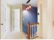 Well-lit hallway featuring modern lighting fixtures and hardwood railing leading to other rooms at 21 Wisteria Run, Hiram, GA 30141