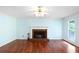 Bright living room featuring hardwood floors and a classic brick fireplace for cozy evenings at 21 Wisteria Run, Hiram, GA 30141