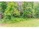 The grassy backyard is heavily wooded with mature trees providing plenty of shade at 2469 Newgate Dr, Decatur, GA 30035