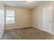 Neutral bedroom featuring a window with blinds, carpet, and a door leading to the hallway at 2469 Newgate Dr, Decatur, GA 30035