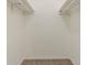 A carpeted walk-in closet offers storage with shelves mounted at the top on either side at 2469 Newgate Dr, Decatur, GA 30035