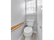 Bright bathroom with a modern toilet, grab bar, and window with blinds for natural light at 10 Bayberry Ct, Acworth, GA 30101