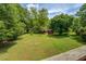 Spacious backyard with lush green grass and mature trees, perfect for outdoor activities at 2821 Highway 11, Mansfield, GA 30055