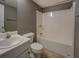 Bright bathroom with a single sink vanity, tiled floors, a toilet, and a bathtub with shower at 2821 Highway 11, Mansfield, GA 30055