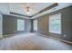 Spacious bedroom featuring three large windows, a ceiling fan, and a tray ceiling for added architectural detail at 2821 Highway 11, Mansfield, GA 30055