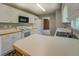 Well-lit kitchen features white cabinets, black microwave, and a white stove and refrigerator at 2821 Highway 11, Mansfield, GA 30055