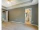 Spacious main bedroom with tray ceiling, neutral carpet, and adjoining bathroom at 2821 Highway 11, Mansfield, GA 30055