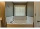 Bathroom featuring a relaxing soaking tub surrounded by white tile and a window at 2821 Highway 11, Mansfield, GA 30055