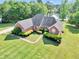 Aerial view of a brick home with well-maintained lawn and lake frontage at 70 Lake Charles Xing, Covington, GA 30016