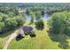 Aerial view showcases a beautiful lakeside property with lush greenery and mature trees at 70 Lake Charles Xing, Covington, GA 30016