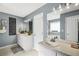 Well-lit bathroom with double sinks, and modern fixtures, tiled floor, and complementary gray paint at 70 Lake Charles Xing, Covington, GA 30016