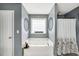 Modern bathroom with jacuzzi tub, tiled floors, stylish decor, a window, and coordinated colors at 70 Lake Charles Xing, Covington, GA 30016
