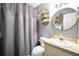 Cozy bathroom featuring a shower with grey shower curtain and a round mirror above the sink at 70 Lake Charles Xing, Covington, GA 30016