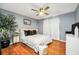 Comfortable bedroom features warm hardwood floors, a ceiling fan, and a large window, creating a relaxing atmosphere at 70 Lake Charles Xing, Covington, GA 30016