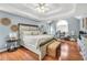 Well-lit and spacious main bedroom with tray ceiling, a seating area, hardwood floors, and modern decor at 70 Lake Charles Xing, Covington, GA 30016