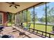 Enclosed patio with seating offers peaceful views of the lush backyard and lake at 70 Lake Charles Xing, Covington, GA 30016