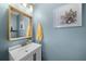 Powder room featuring an interesting framed mirror and light-blue painted walls at 164 Stoneforest Dr, Woodstock, GA 30189