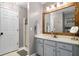 Bathroom featuring a large vanity with a wood-framed mirror and a glass-enclosed shower with a white tiled surround at 164 Stoneforest Dr, Woodstock, GA 30189