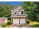 Beautiful home exterior with two-car garage, brick facade, and lush green surroundings at 164 Stoneforest Dr, Woodstock, GA 30189