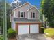 Side view of a two-story home with neutral siding, brick accents, and a two-car garage at 164 Stoneforest Dr, Woodstock, GA 30189