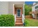 Charming brick home entrance with well-maintained landscaping, white railing and blue front door at 164 Stoneforest Dr, Woodstock, GA 30189