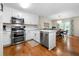 Lovely kitchen with stainless appliances, white cabinets, hardwood flooring, and lots of counter space at 164 Stoneforest Dr, Woodstock, GA 30189