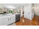 The kitchen features stainless appliances, white cabinets, hardwood floors, and lots of natural light at 164 Stoneforest Dr, Woodstock, GA 30189