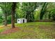 Spacious green backyard featuring a white shed and tree coverage at 1819 Waldrep Se Cir, Marietta, GA 30060