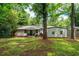 Backyard featuring a white home exterior surrounded by lush green trees and grass at 1819 Waldrep Se Cir, Marietta, GA 30060