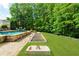 Backyard features include a sparkling pool, well-manicured lawn, and a bocce ball court at 2325 Manor Creek Ct, Cumming, GA 30041