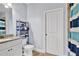 Bright bathroom with granite countertops, tile floors, a toilet, shelving and storage, and a shower with blue curtain at 2325 Manor Creek Ct, Cumming, GA 30041