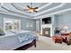 Spacious bedroom featuring a fireplace, tray ceiling, and a cozy seating area, perfect for relaxation and comfort at 2325 Manor Creek Ct, Cumming, GA 30041