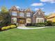 A stately brick home featuring manicured landscaping, detailed architectural elements, and a welcoming entryway at 2325 Manor Creek Ct, Cumming, GA 30041
