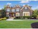 A stately brick home featuring manicured landscaping, detailed architectural elements, and a welcoming entryway at 2325 Manor Creek Ct, Cumming, GA 30041