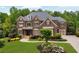 Traditional brick home with lush landscaping, mature trees, and attached garage at 2325 Manor Creek Ct, Cumming, GA 30041
