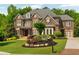 Beautiful brick home featuring manicured lawn and mature landscaping at 2325 Manor Creek Ct, Cumming, GA 30041