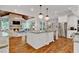 This open concept kitchen and living room has hardwood floors, white cabinets, and granite countertops at 2325 Manor Creek Ct, Cumming, GA 30041