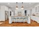 A modern kitchen featuring hardwood floors, white cabinets, stainless appliances, and a large center island at 2325 Manor Creek Ct, Cumming, GA 30041