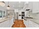Modern kitchen features white cabinets, stainless appliances, granite countertops, and hardwood floors at 2325 Manor Creek Ct, Cumming, GA 30041