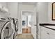 Bright laundry room featuring modern stainless steel machines, tiled floors, and a built-in sink with granite countertops at 2325 Manor Creek Ct, Cumming, GA 30041