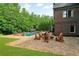 Paver patio with seating area and fire pit overlooks the sparkling swimming pool at 2325 Manor Creek Ct, Cumming, GA 30041