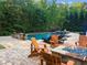 Backyard with pool, spa, and firepit, and wood adirondack chairs on a paved patio at 2325 Manor Creek Ct, Cumming, GA 30041
