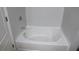 Bathroom featuring a pristine white tub with modern fixtures and a clean, minimalist aesthetic at 2476 Suwanee Pointe Dr, Lawrenceville, GA 30043